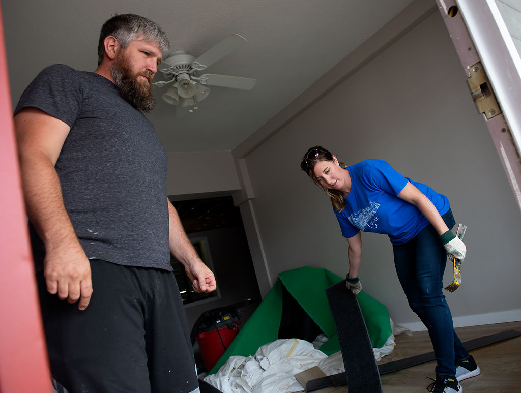 Jeremy and Jennifer Hart clear out waterlogged flooring from one of the rooms